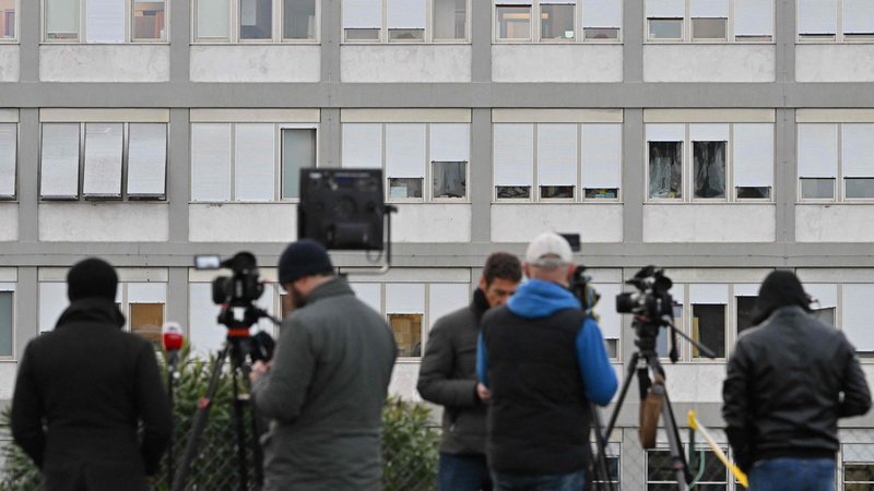 Fotografija: Pred bolnišnico Gemelli stojijo novinarji, kamere neštetih televizijskih ekip so usmerjene v deseto nadstropje, kjer leži Frančišek v posebnem apartmaju, namenjenem papežem. FOTO: Alberto Pizzoli/AFP