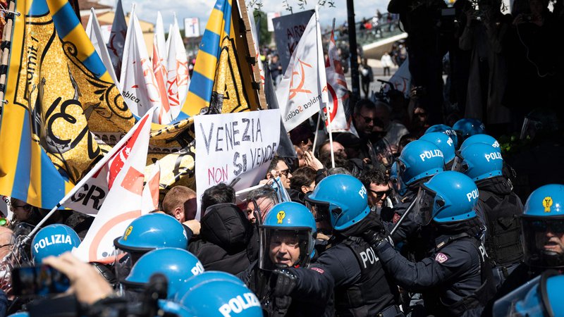 Fotografija: Jezne Benečane so morali ustaviti policisti. FOTO: Marco Bertorello/AFP