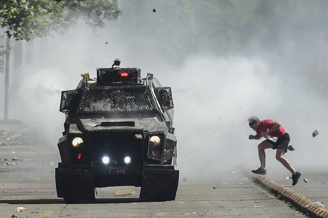 V nemirih v Čilu je doslej umrlo najmanj 13 ljudi, predsednik Pinera pa poskuša stvari umiriti. FOTO: Martin Bernetti/AFP