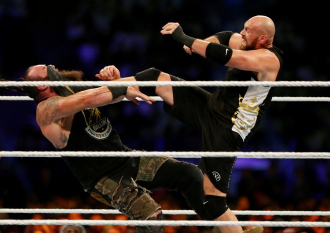 Tyson Fury (desno) je z nedavno zmago nad Braunom Strowmanom v wrestlingu zaslužil skoraj petnajst milijonov evrov. FOTO: Reuters
