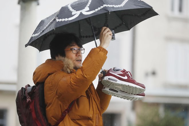 Da bi ovekovečili turistično znamenitost, si je včasih treba zmočiti noge. FOTO: Leon Vidic