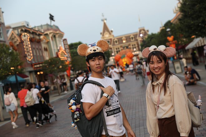 Navdušena turista v hongkonškem Disneylandu. FOTO: Reuters