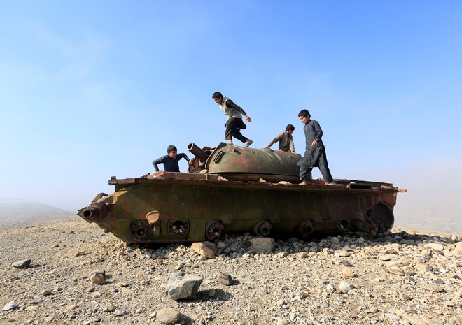 Otroci se igrajo na zapuščenem ruskem tanku. FOTO: Reuters