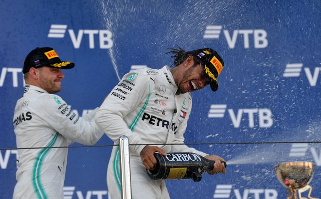Valtteri Bottas, ki je z drugim mestom zaokrožil dvojno zmago Mercedesa v Sočiju, je s šampanjcem poškropil Lewisa Hamiltona. FOTO: AFP