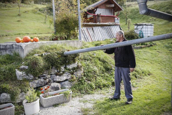 Darko Prijatelj s Finkovega se, tako kot vsi prebivalci vasi, z vodo oskrbuje iz kapnice, v katero se steka voda s streh. FOTO: Uroš Hočevar/Delo