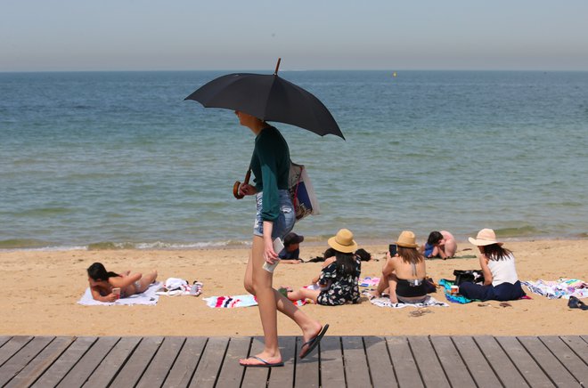 Na plaži na včerajšnji rekordno vroč dan v avstralski zvezni državi Viktoriji. FOTO: Stringer via Reuters