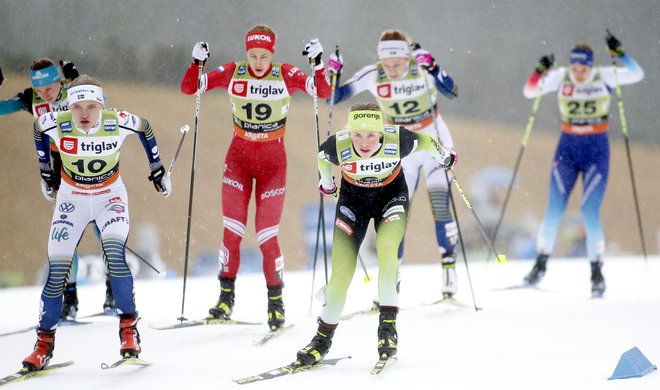 Vodilna slovenska tekačica (v ospredju desno) se je odločno lotila slehernega nastopa v dežju pod Poncami. FOTO: Roman Šipić/Delo