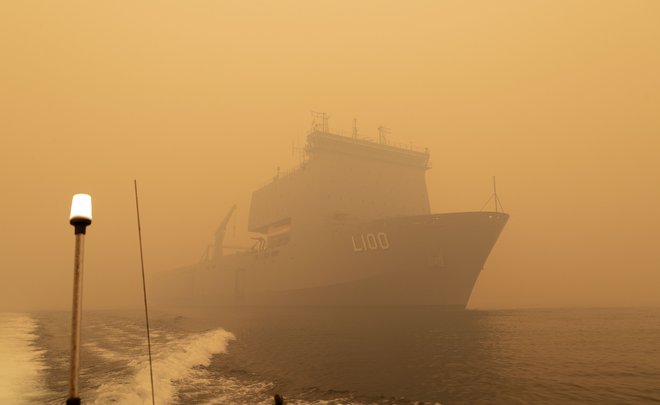 Vojaška ladja HMAS Choules bo ljudi z obale Mallacoota vozila na varno. FOTO: Helen Frank, Royal Australian Navy/AFP