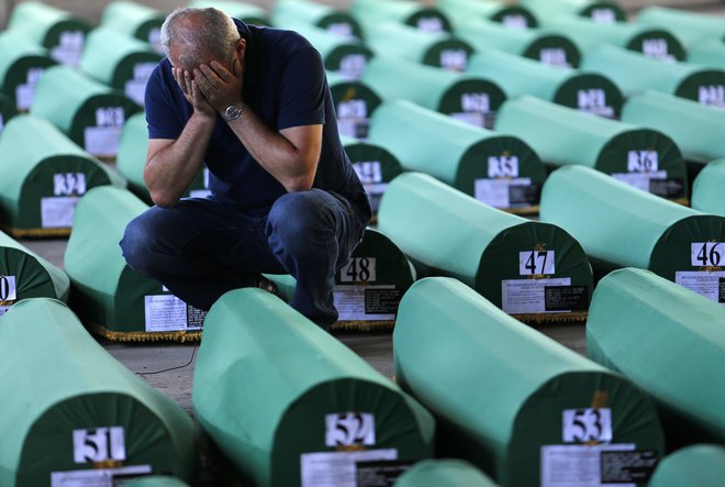 V povorkah avtomobilov, traktorjev in tovornjakov, ki vozijo mimo spominskega parka v Potočarih, plapolajo iste srbske zastave, v imenu katerih je bil storjen genocid. FOTO: Tomi Lombar/Delo