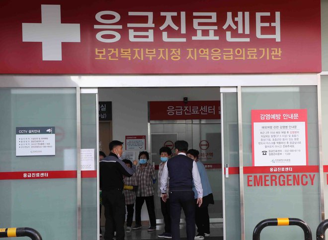 Dezinfekcija v bolnišnici v Južni Koreji, v kateri je izolirana okužena bolnica. FOTO: AFP