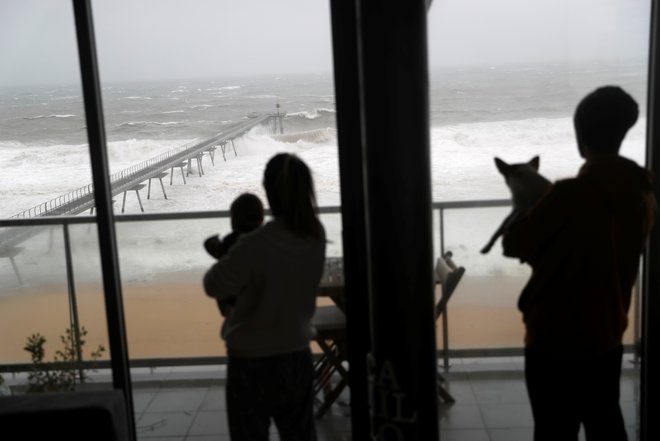 Družina opazuje razjarjeno morje zaradi nevihte Gloria, ki je zajela španska obalna mesta. FOTO: Reuters/Nacho Doce&nbsp;