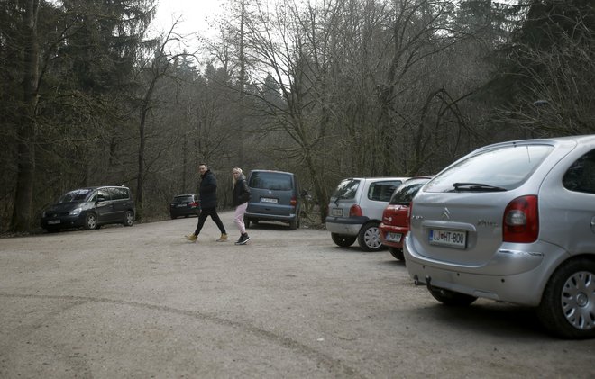 Zavijanje na makadamsko cesto, ki vodi proti vodohranu, je prepovedano, a je ob cesti vedno veliko parkiranih vozil. FOTO: Blaž Samec/Delo