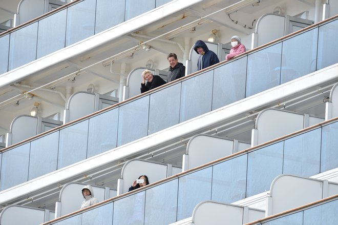 Potniki na krovu križarke&nbsp;Diamond Princess ob prihodu v pristanišče Jokohama. FOTO: Kazuhiro Nogi/AFP