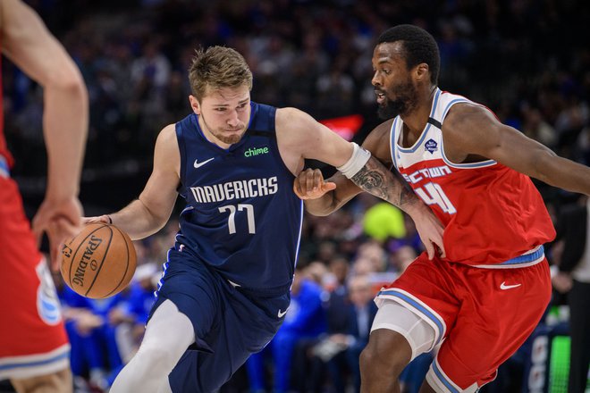 Luka Dončić prodira mimo igralca Sacramenta Harrisona Barnesa. FOTO: Reuters