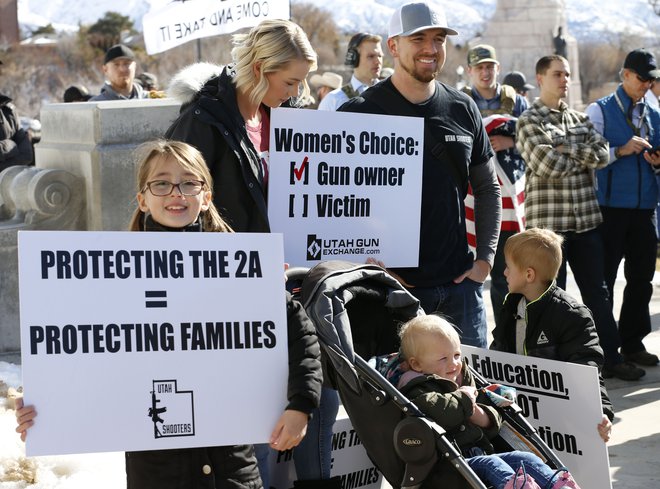 Ameriška družina, ki se zavzema za pravico do nošenja orožja, posluša govorce na protestu proti novi zakonodaji o orožju v Salt Lake Cityju. Protestniki nasprotujejo novi zakonodaji o orožju, za katero pravijo, da bo omejila njihove pravice, ki jih dovoljuje drugi amandma. FOTO: George FreyAfp