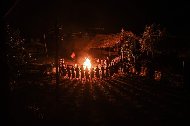 Članice plemena Gongwang Bonyo, ki so med najbolj izoliranimi skupnostmi v Burmi, med celonočnim obredom plešejo ob tabornem ognju, da bi blagoslovili prihodnjo letino. FOTO: Ye Aung Thu/Afp<br />
&nbsp;