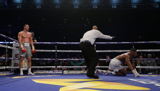 Ukrajinski boksarski šampion Vladimir Kličko (levo) je takole pred dvema letoma v šesti rundi poslal na tla britanskega zvezdnika Anthonyja Joshuo. FOTO: Reuters