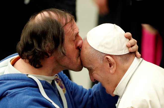 Na papeževi tedenski avdienci v Vatikanu je eden od vernikov poljubil svetega očeta na čelo. FOTO: Yara Nardi/Reuters