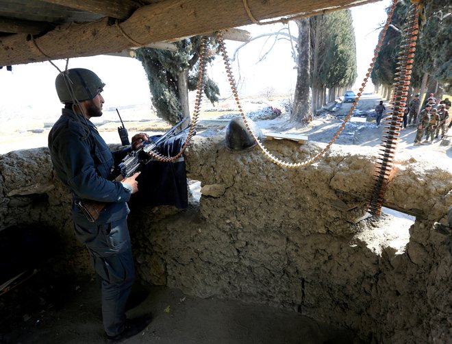 Pripadnik afganistanskih varnostnih sil v bližini mesta, kjer sta bila pred tem ubita ameriška vojaka.&nbsp;Foto Parwiz Parwiz Reuters