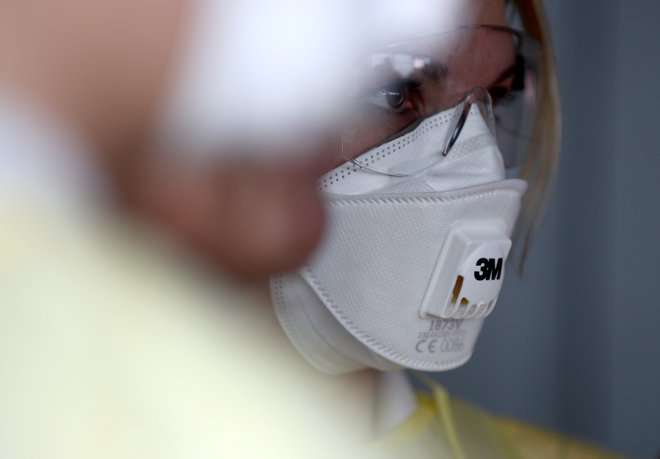 Za zaščito pred koronavirusom naj bi bile primerne zaščitne maske s certifikatom FFP3 ali N95, medtem ko navadne kirurške maske po mnenju zdravnika Blaža Mrevljeta niso ustrezne. FOTO: Lisi Niesner/Reuters