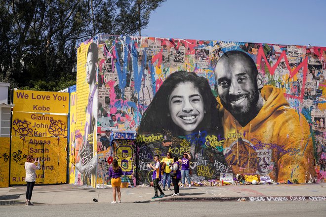Ljudje se redno zbirajo pred grafitom, na katerem sta narisana Kobe Bryant in njegova hčerka Gianna. FOTO: Reuters