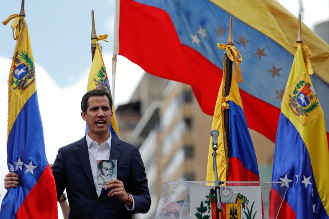 Predsednik venezuelskega državnega zbora Juan Guaido s kopijo venezuelske ustave v rokah. FOTO: Carlos Garcia Rawlins/Reuters