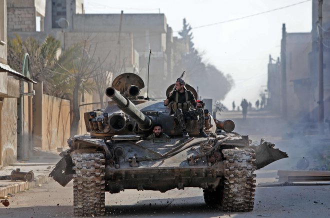 Na fotografiji sirski uporniki, nekatere od njih podpira Turčija, v strateško pomembnem mestu Saraqib. FOTO: Bakr Alkasem/AFP