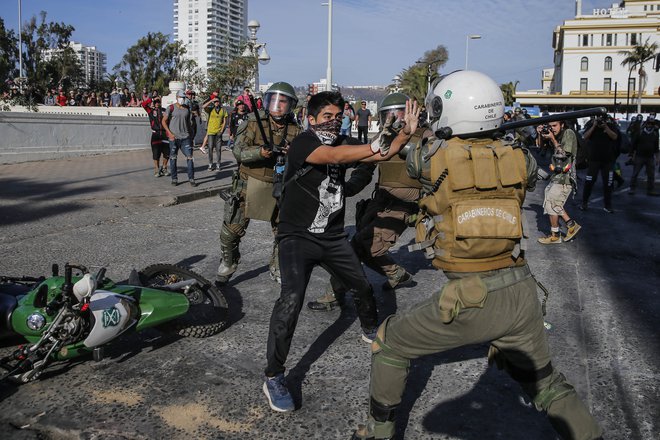 Protivladni protesti v Čilu se nadaljujejo tudi letos. Na fotografiji spopad policista in protestnika v letovišču Vina del Mar. FOTO: Javier Torres/AFP