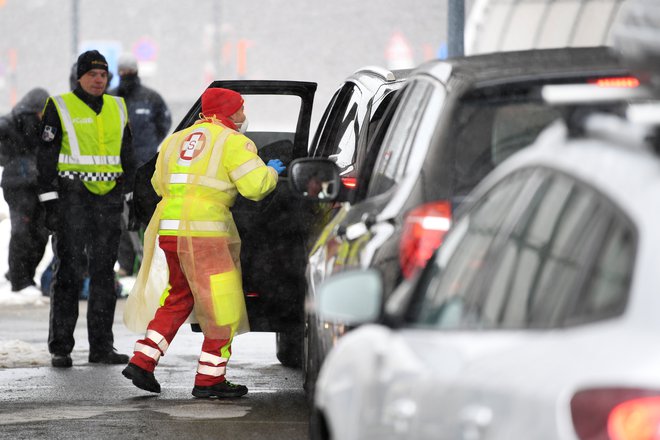 Medicinsko osebje na prelazu Brenner med merjenjem temperature voznikom, ki prihajajo iz Italije. FOTO: Andreas Gebert/Reuters