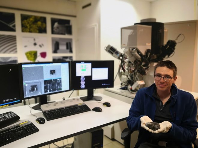 Ambrožič z drugim najdenim delom meteorita Novo mesto v laboratoriju Centra odličnosti nanoznanosti in nanotehnologije. FOTO: Bojan Ambrožič