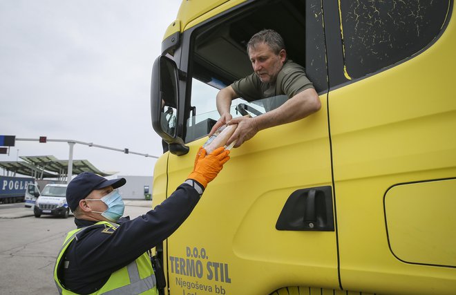 Večina voznikov tovornjakov je po štirih dneh čakanja prvič dobila vodo in sendviče ki jih deli slovenska Policija. Mejni prehod Obrežje 13.3.2020. FOTO: Jože Suhadolnik/Delo