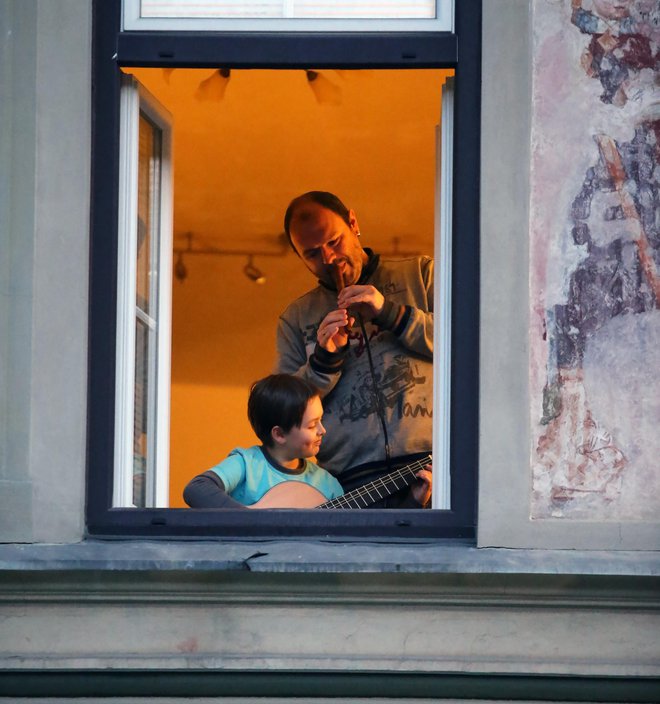 Klarinetist Goran Bojčevski in njegov sin Taras sta sinoči muzicirala ob odprtem oknu v Celju. FOTO: Andraž Purg - GrupA
