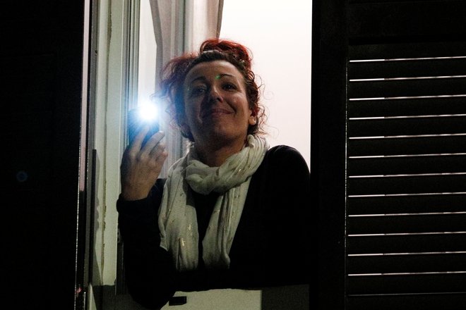 Italijani so k petju in muziciranju na balkonih dodali še prižiganje lučk. Dvigovanje morale z akcijo Razsvetlimo Italijo. FOTO: Guglielmo Mangiapane/Reuters