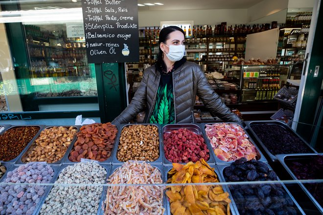 Prodajalka na najbolj priljubljeni dunajski tržnici Nashmarkt si je nadela zaščitno masko. FOTO: Reuters