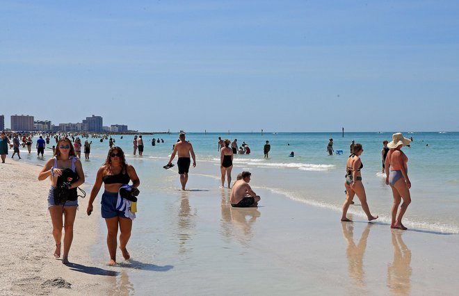 Kljub uradnim opozorilom se na floridskih plažah še vedno zbirajo kopalci. FOTO: Mike Ehrmann/AFP