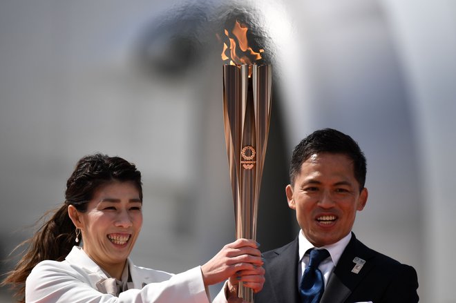 Olimpijski ogenj sta na Japonskem sprejela trikratna olimpijska prvaka, rokoborka Saori Jošida in judoist Tadahiro Nomura. FOTO: AFP