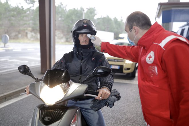 Prostovoljci Rdečega križa na mejah merijo telesno temperaturo. FOTO: Voranc Vogel/Delo