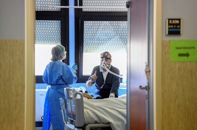 Zdravstvena delavka oskrbuje pacienta z boleznijo covid-19 v bolnišnici Oglio Po v Cremoni. Foto: REUTERS/Flavio Lo Scalzo