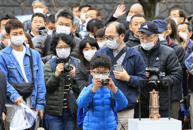 Japonci se še vedno zgrinjajo v dolgih vrstah, da bi od blizu videli olimpijski ogenj. FOTO: Reuters