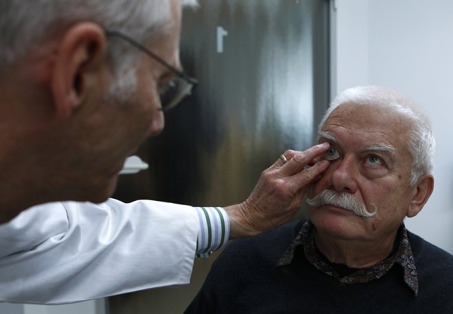 Pri okulističnem pregledu sta pacient in zdravnik v neposrednem stiku, prenos okužbe je brez zelo dobre zaščitne opreme zelo verjeten. FOTO: Reuters