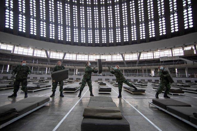 Srbska vojska pripravlja postelje na gospodarskem razstavišču v Beogradu. Foto Reuters