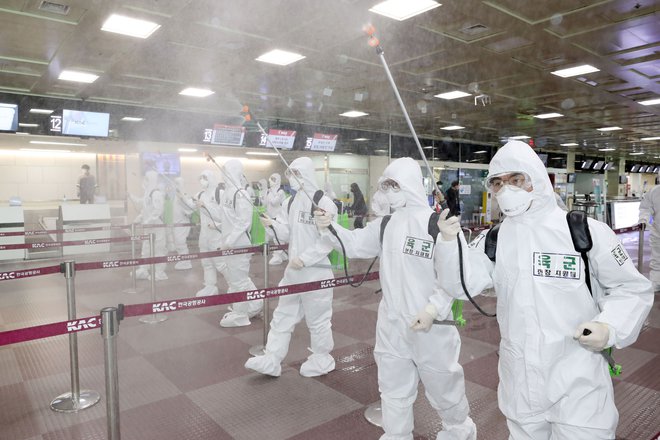 Južnokorejski vojaki razkužujejo letališče. FOTO: Afp