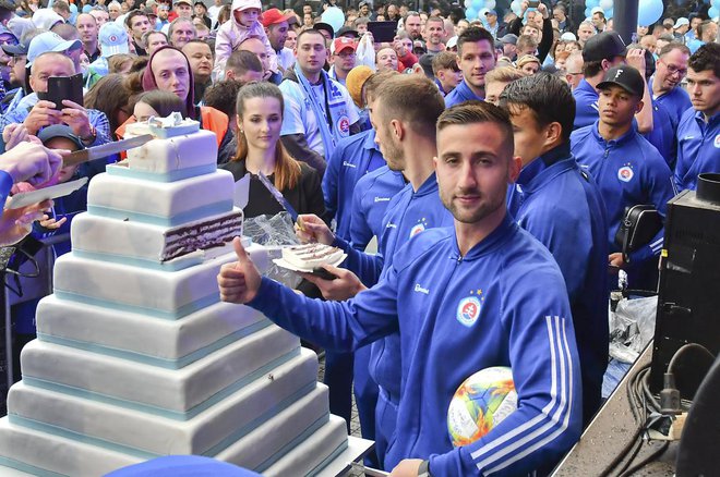 Andraž Šporar se je z veseljem stisnil k torti, ki je bila del praznovanja stoletnice Slovana iz Bratislave. FOTO: Slovan Bratislava
