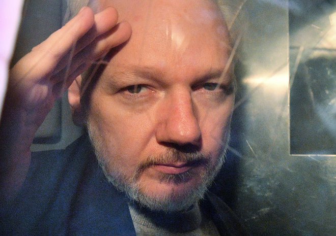 Julian Assange leta 2019, na poti v zapor. FOTO: AFP
