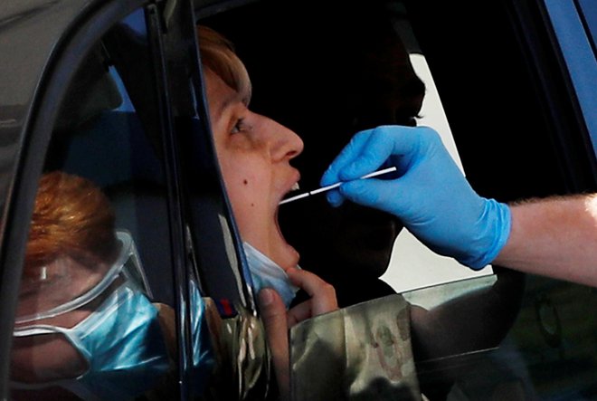 Na Otoku je test za koronavirus možno opravičiti za volanom svojega avtomobila. Foto: REUTERS/Peter Nicholls