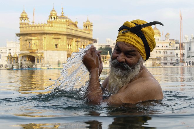 Indijski Sikhi med festivalom Baisakhi molijo pred Zlatim templjem v Amritsarju med karanteno. FOTO: Narinder Nanu/AFP