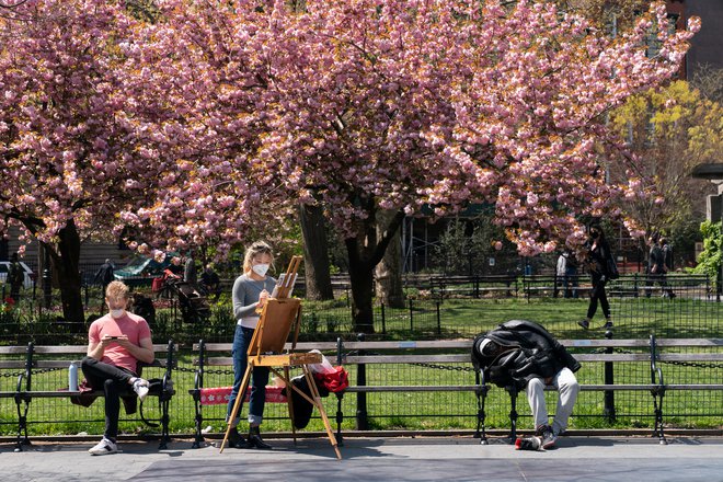 Obiskovalci parka na Washington Square v New Yorku. Razmere se tam počasi popravljajo. Foto Reuters.