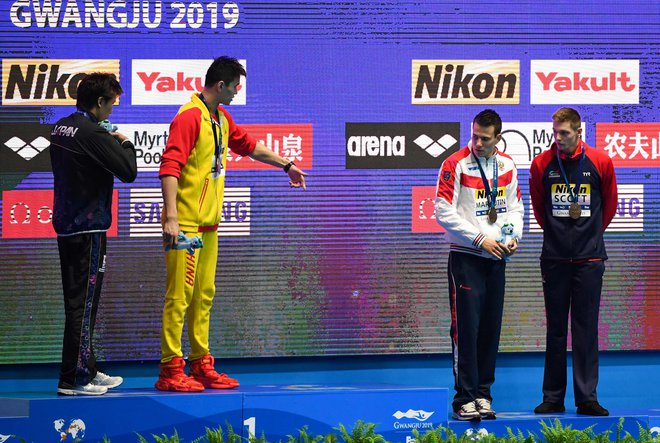 Svetovni prvak na 200 m prosto Sun Yang (drugi z leve), ob katerem je srebrni Japonec Macumoto, je na najvišjo stopničko povabil Rusa Maljutina in Britanca Scotta, ki sta si delila tretje mesto. Slednji ga je zavrnil. FOTO: AFP