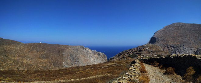 Nekje na sredi otoka se z glavne ceste prašna cestica vzpne v zarezo grebena in doseže pobočje Kapsala. FOTO: Aleš Nosan