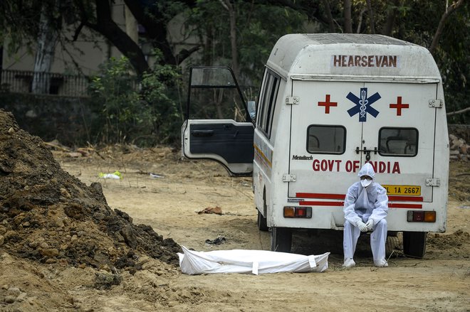 Žrtve je virus zahteval širom sveta, na fotografiji pokop v Indiji. FOTO: Sajjad Hussain/Afp